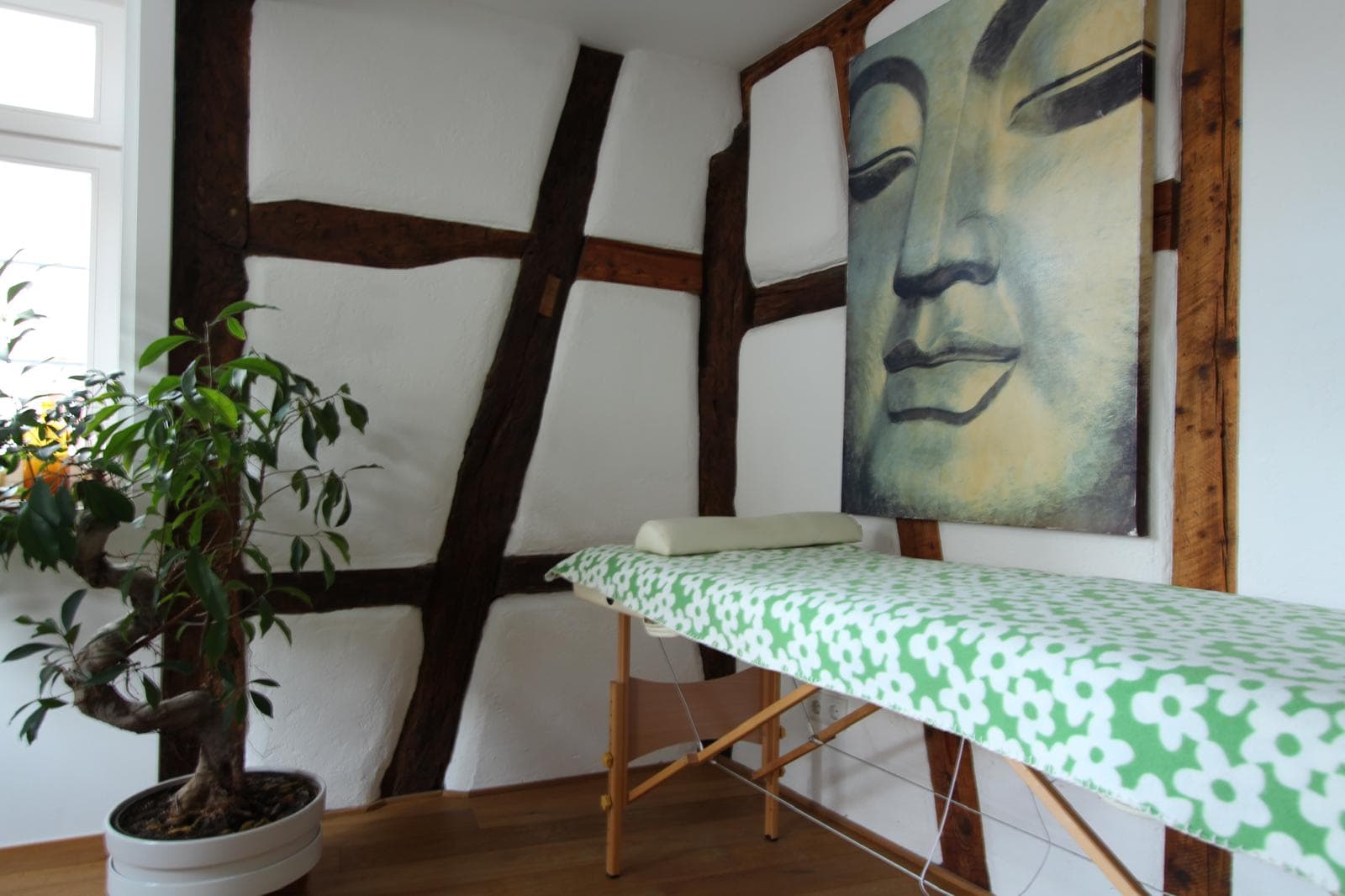 Der Reiki-Raum mit Liege, Buddha-Bild und Fachwerk
